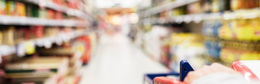 Close up of woman using shopping cart in supermarket.