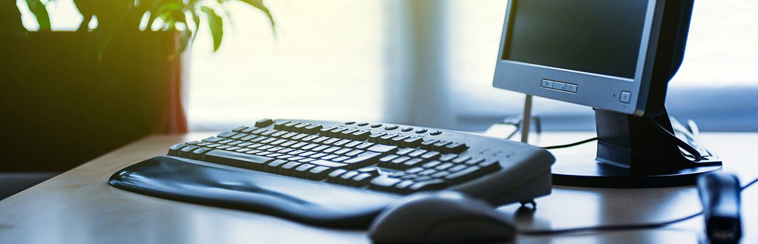 Modern Computer on desk in office lit by sun